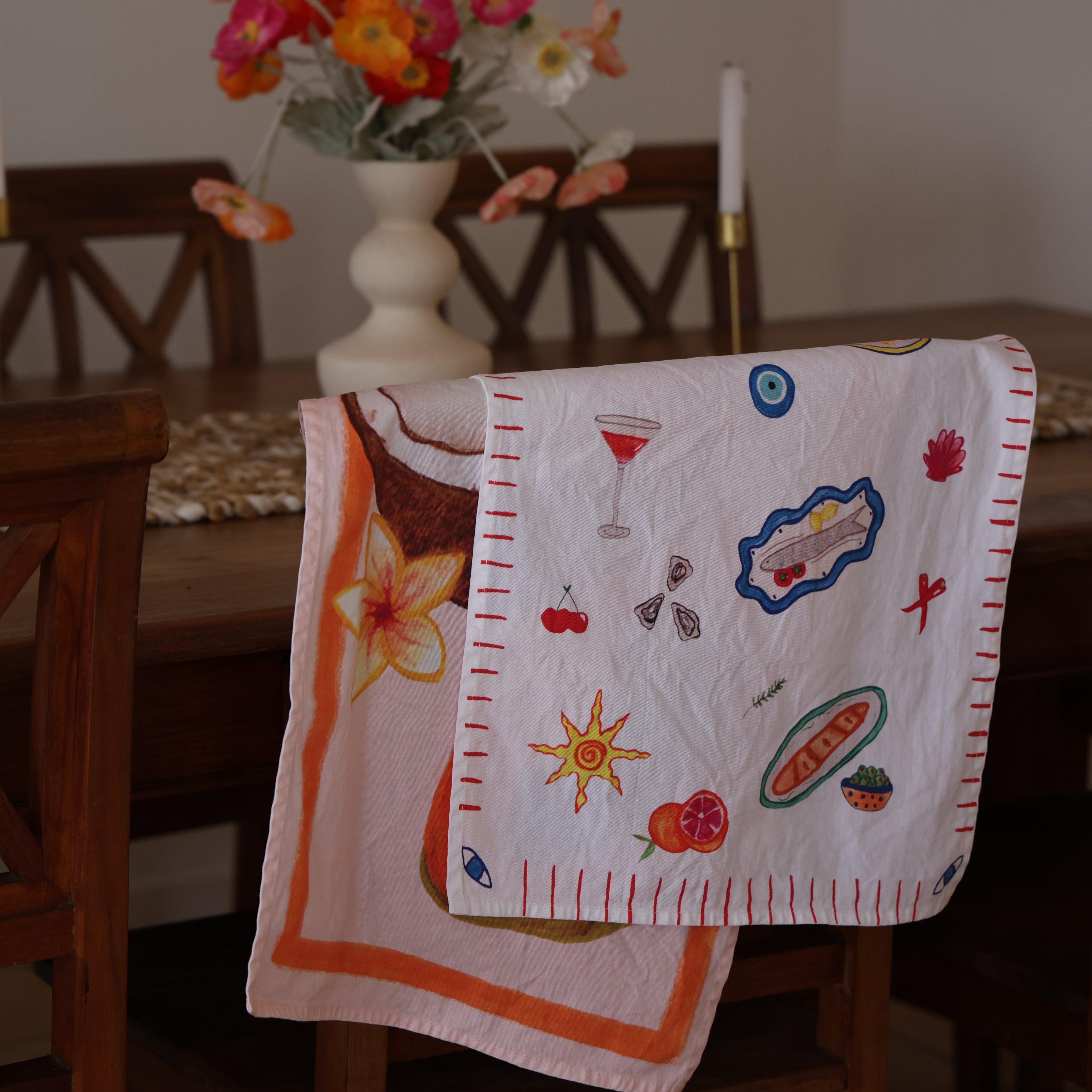 Decorative tea towel with colorful patterns on a wooden surface.