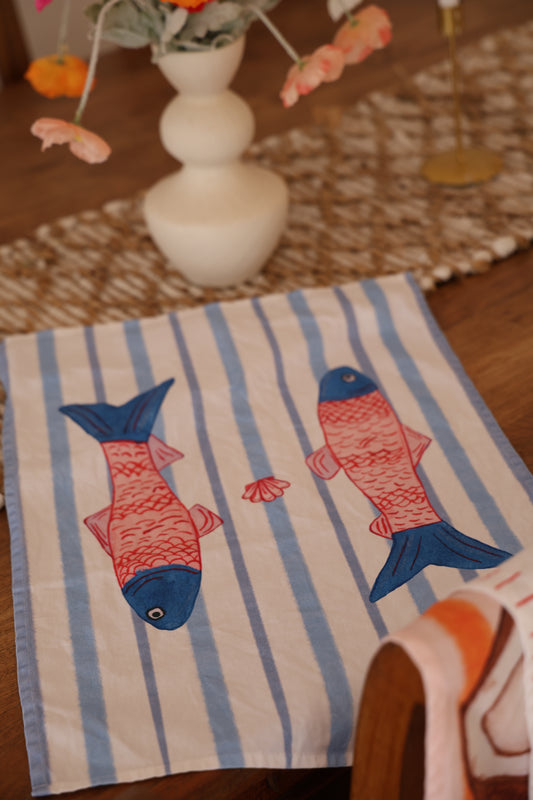 Striped towel with fish design on a wooden surface